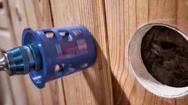 Perçage d'une grande ouverture circulaire à la scie cloche dans un mur en bois.